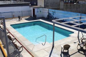恩塞纳达港Hotel La Quinta Bonita的一座游泳池,位于一座带椅子的建筑中