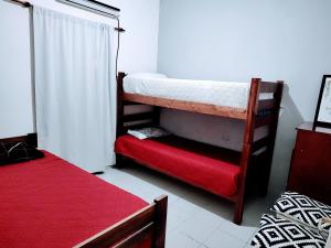 MacoC & J Casa de alquiler的客房配有两张双层床和红色床垫。