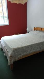 戈多伊克鲁斯Maria Delicia的卧室配有白色的床铺和红色的墙壁