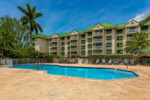 基韦斯特Sunrise Suites Barbados Suite #204的一座大型公寓楼,前面设有一个游泳池