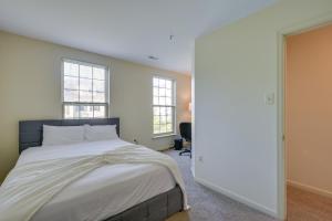 奥因斯米尔斯Owings Mills Townhouse 8 Mi to Liberty Reservoir!的一间卧室设有一张大床和两个窗户。