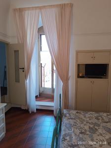 诺奇Locazione turistica La vecchia arcata的一间卧室配有床和带窗帘的窗户