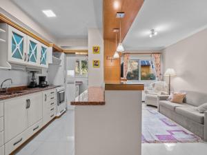 格拉玛多Araucárias 302的厨房以及带白色橱柜和沙发的客厅。