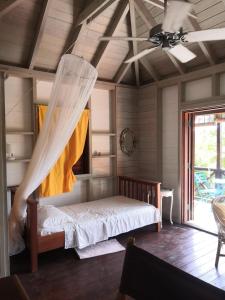 英吉利港Rotten Hill Retreat Cottages的一间卧室配有一张带蚊帐的床