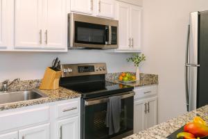 华盛顿Sonder Georgetown C&O的厨房配有白色橱柜和黑烤箱。