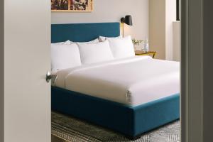 华盛顿Sonder Georgetown C&O的一间卧室配有一张大床和蓝色床头板