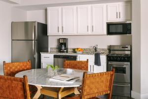 华盛顿Sonder Georgetown C&O的厨房配有白色橱柜和桌椅