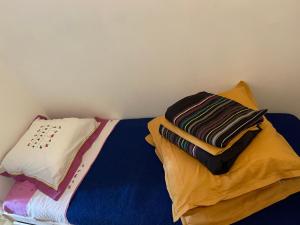 拉格朗德默特Studio Cabine Clim Wifi Parking Draps - 1 étoile - self check-in possible的床上铺有色彩缤纷的床单和枕头