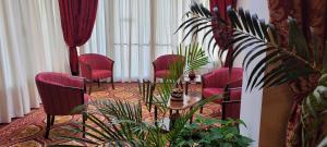 AltedoHOTEL PARADISO的一间设有红色椅子、桌子和植物的房间
