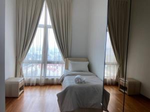 科塔达曼萨拉Tropicana Grande Luxurious Stay的卧室设有一张位于大窗户前的床铺。