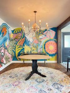 坦帕Luxury - Pet Friendly, Farmhouse Bungalow DT Tampa的一间带吊灯和壁画的用餐室