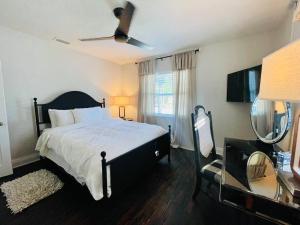 坦帕Luxury - Pet Friendly, Farmhouse Bungalow DT Tampa的一间卧室配有一张床和吊扇