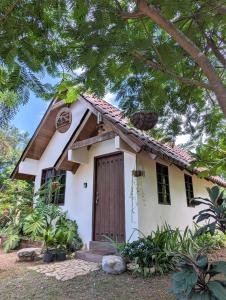 CañasDidi Lodge - Cabaña cálida y acogedora!的一间白色的小房子,设有棕色的门