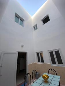 西迪伊夫尼Panorama guest house的白色的客房配有桌椅和窗户。