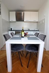 普莱曼图拉Apartman Cinkopan Premantura 1的白色餐桌和一瓶葡萄酒