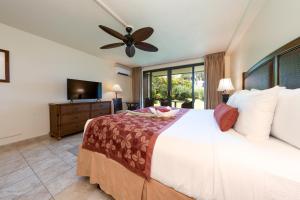普林斯维尔哈纳雷湾度假酒店的一间卧室配有一张大床和吊扇