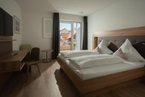 海利根堡霍斯贝恩旅馆的一间卧室配有一张床、一张书桌和一个窗户。