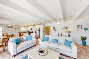 基克罗尼海滩Breezy Keys的客厅配有2张白色沙发和1张桌子