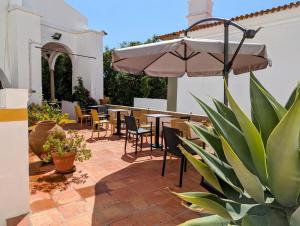 埃武拉索拉蒙发林姆酒店的一个带桌椅和遮阳伞的庭院