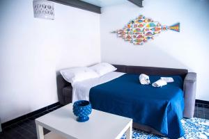 维耶特里Casa Blu的一间卧室配有一张带蓝色毯子和一张桌子的床。