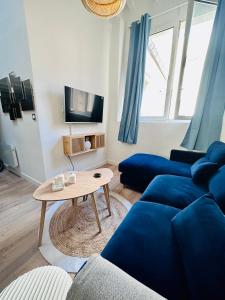 尼姆L'Etoile - Duplex cosy de 50m2 en centre-ville的客厅配有蓝色的沙发和桌子