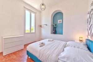胡安莱潘Maison Sara Juan les Pins的白色的卧室设有床和窗户