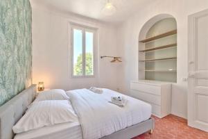 胡安莱潘Maison Sara Juan les Pins的白色的卧室设有床和窗户