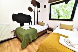韦特利纳Za Górami的一间卧室设有两张床,墙上挂着一只熊