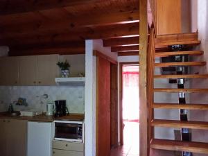 帕琉乔拉Olive tree Cottages的厨房设有楼梯,通往带柜台的厨房