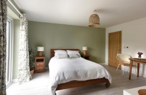 德拉布尔The Garden Room的一间卧室配有带白色床单和枕头的床。