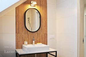 鲁恰内尼达Mazury Haus的浴室设有水槽和墙上的镜子