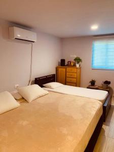 La PlayaMini Casa Campestre Privada的一间卧室设有两张床、一个梳妆台和窗户。