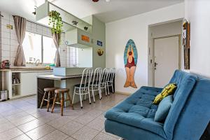 弗洛里亚诺波利斯Apto a 30 metros do mar em Canasvieiras CBE105的一间带蓝色沙发的客厅和一间厨房