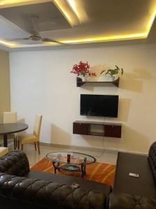 洛美S2A apparts的客厅配有沙发和墙上的电视