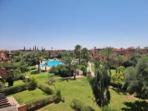 马拉喀什La Perle de Marrakech by Atlas Golf Resort的一个带游泳池和棕榈树的度假村