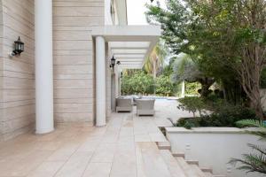 荷兹利亚Luxurious & Exclusive Villa, 10 min from the beach的户外庭院拥有白色的柱子和树木