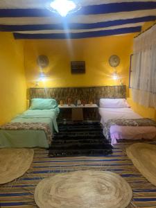 艾西拉Dar Garindi的一间设有两张床的房间和蓝色及黄色的墙壁