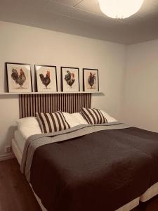 VångaLe Coq Heureux的卧室配有一张四幅画的墙壁床。