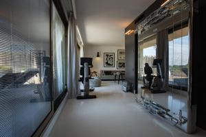 波尔图·埃尔科莱Argentario Golf & Wellness Resort的一间设有跑步机和窗户的健身房的客房