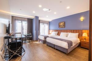 伊斯坦布尔La Wisteria Boutique Hotel Istanbul的酒店客房配有两张床和一张书桌