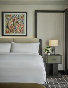 纽波特海滩Pendry Newport Beach的卧室配有白色的床和带台灯的桌子