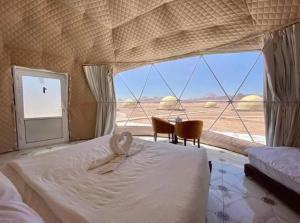 亚喀巴Wadi Rum Gulf camp的一间带沙发床的卧室,享有沙漠美景