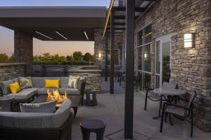 温莎SpringHill Suites by Marriott Loveland Fort Collins/Windsor的一个带沙发和火坑的庭院