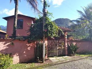 瓜皮米林Guapimirim Casa de Campo的一座带围栏和棕榈树的房子