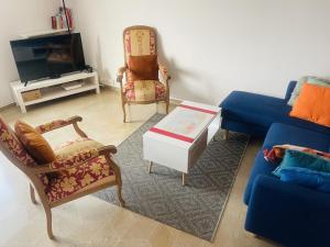 图尔Chambre privée - Place Verdun Tours的客厅配有蓝色的沙发和椅子