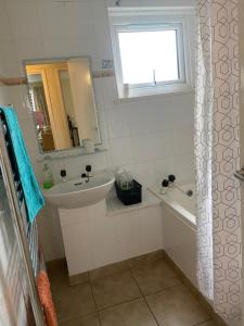 利物浦Home with a view的一间带水槽、浴缸和镜子的浴室