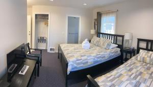 温哥华甘比山林小屋的一间卧室配有两张床和一张桌子及椅子