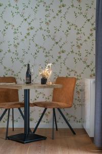 HeikruisB&B T'Rest - Park ter Rijst的餐桌、椅子和花卉壁纸墙