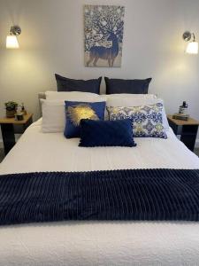 AberdareHamptons House on Hunter with fire pit的一张配有蓝色和白色枕头的大床