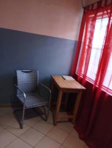 KpaliméBM Akwaba的窗户房间里一张椅子和一张桌子